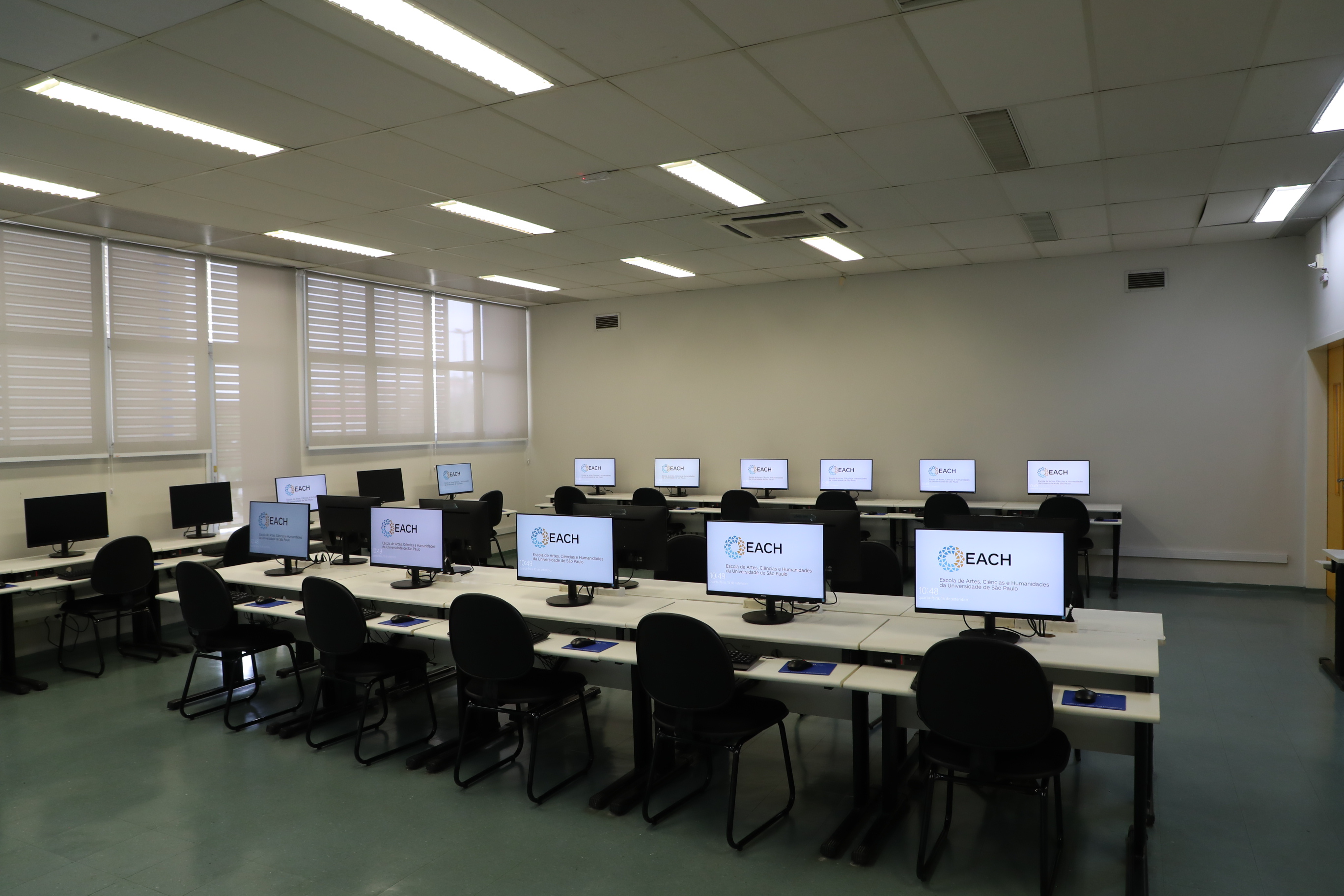 sala de aula vazia com computadores pretos